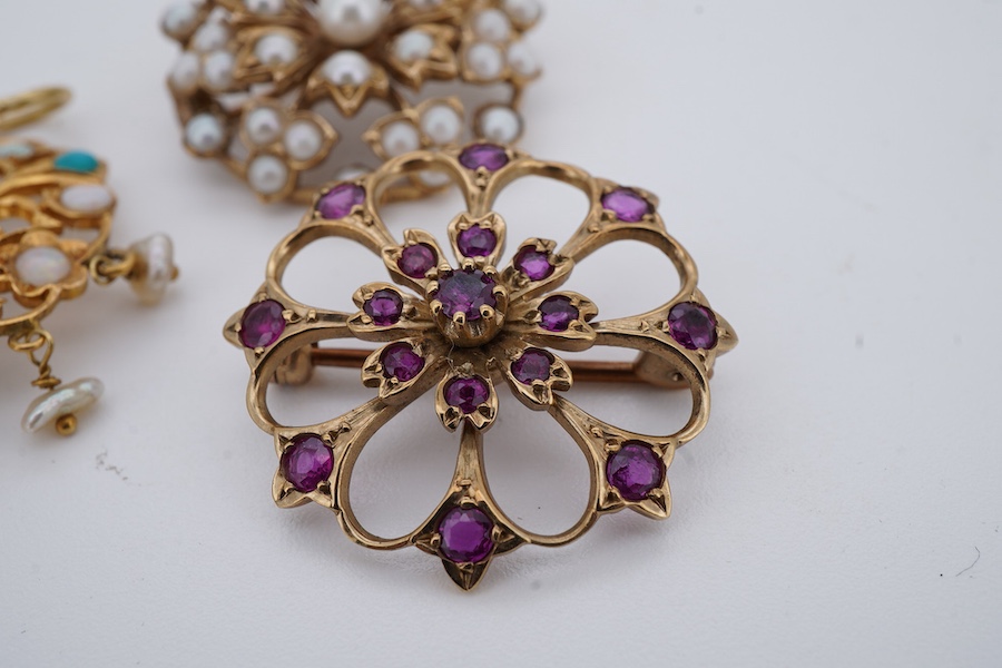 Two brooches and a pendant, each of floral design, the brooches set with circular-cut garnets, and seed pearls respectively each mounted in 9ct gold, British hallmarks, combined gross weight 11 grams, the pendant set wit